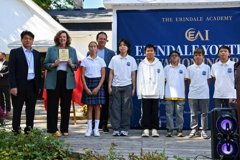 Middle school student representatives present an honorary mentor certificate.